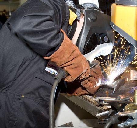 The welder in protective clothes behind jobの写真素材