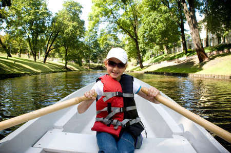 The girl in the boat on oars on the channel in Riga