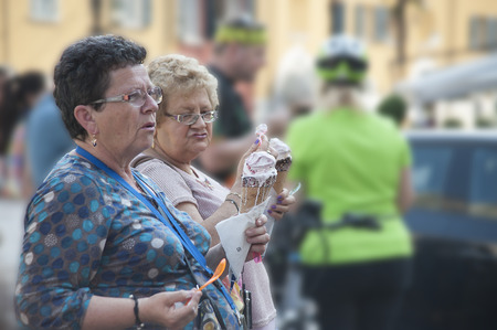 Garda, Itali - May 18,2015: Two corpulent ladies talk, holding huge portions of the ice cream corresponding to their proportions in hand.のeditorial素材