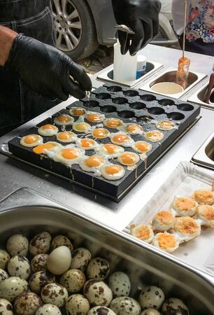 Frying and selling quail eggs on the stove in the bazaar.の写真素材