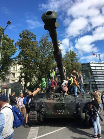 Riga, Latvia, July 06 2019: Inspection of the tank at an arms exhibition in Riga. A group of children on the tank.のeditorial素材