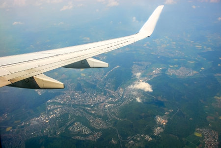 Kind on the earth from plane salon. View of the ground from the aircraft cabin. City skyline under the wingの写真素材