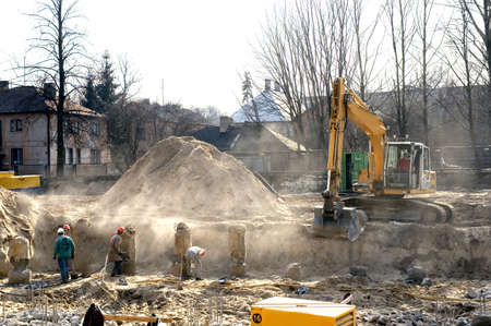 Home construction begins. Digging a pit with an excavator and the work of builders.の写真素材