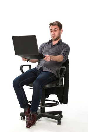 clerk of works with a laptop in hand while sitting on a chair, studio white backgroundの写真素材