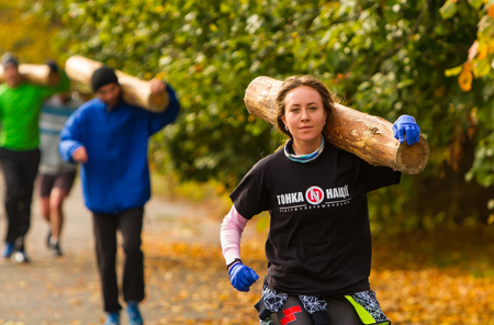 Kyiv, Ukraine - October 08/2016. Outdoor CrossFit training, preparation for competition "Race Nation." Autumn, Kyiv. Group of athletes running with logs in their hands.のeditorial素材
