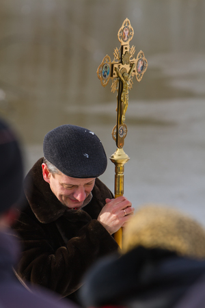 Rovzhi, Ukraine - January 19, 2014 Christian holiday Baptism in the Orthodox calendar. The man bowed his head in prayer holding orthodox cross with the crucifixion of Jesus.のeditorial素材