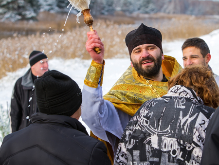 Rovzhi, Ukraine - January 19, 2014 Christian holiday Baptism in the Orthodox calendar.  Father emotionally and abundantly sprinkles parishioners with holy water.のeditorial素材