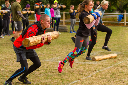 Kyiv, Ukraine - October 08/2016. Outdoor CrossFit training, preparation for competition "Race Nation." Autumn.  Man and woman performing the long jump with a log on his hands.のeditorial素材