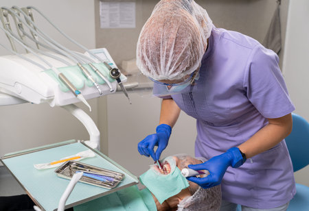 The dentist uses a cotton swab to apply the medicine to the patient's gums, in order to heal the...