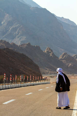 a Bedouin man stands on the road waiting for transport, Wady Megarah, Sinai, Egyptの写真素材