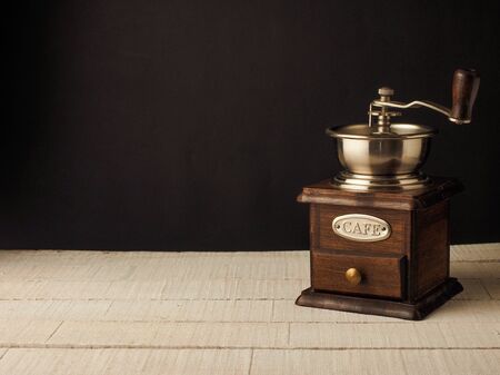 Close-up vintage coffee grinder mill on a dark and light wooden background.の写真素材