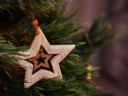Wooden star New Year Tree Christmas toys and flashlights on the Christmas tree close-upの写真素材