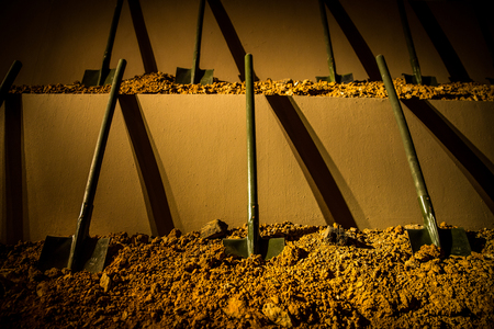 Six symmetrically placed shovels stuck into the groundの写真素材