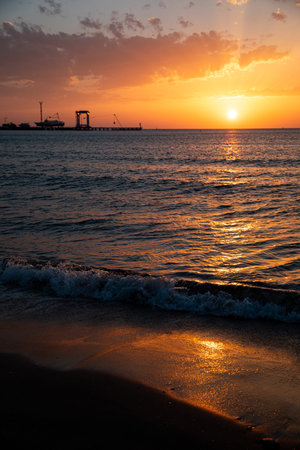 A stunning sunset unfolds beautifully over the ocean waves and the picturesque pier