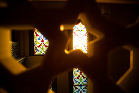 A beautiful stained glass window can be seen through a wooden fence