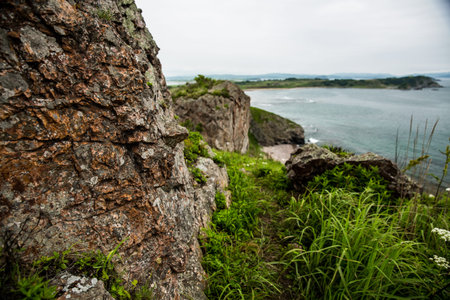 A steep, rocky cliff that beautifully overlooks a vast body of water
