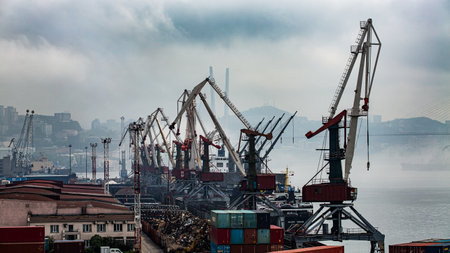 A busy harbor scene filled with numerous cranes and many containersの写真素材