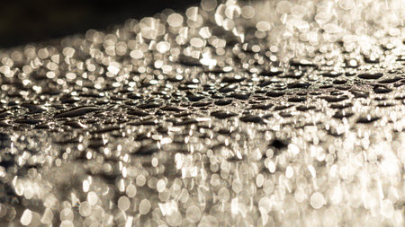 Glittering and Shimmering Water Droplets on a Surface Exposed to Beautiful Sunlight and Natural Lightの写真素材