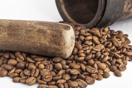 Mortar and pestle with coffee seeds closeup in studio on white backgroundの写真素材