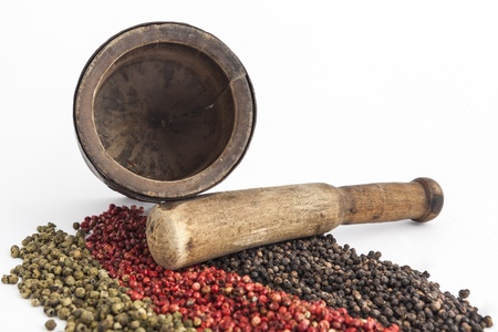 Mortar and pestle with pepper seeds closeup in studio on white backgroundの写真素材