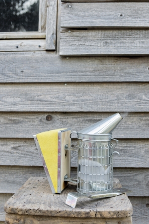 beekeeping equipment, smoker in new condition with old wooden wall as backgroundの写真素材