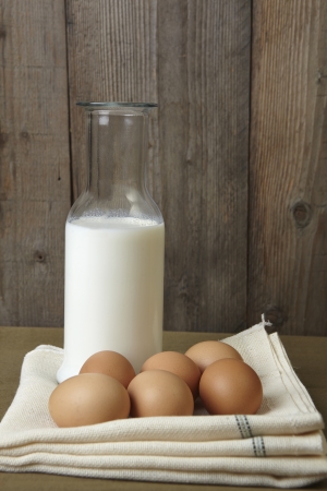 Group of eggs and a bottle of milk on the kitchen counter.の写真素材