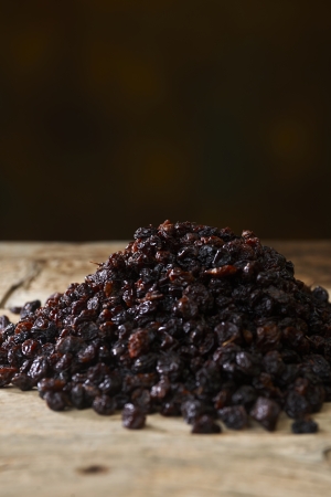 Black raisins over wooden tableの写真素材