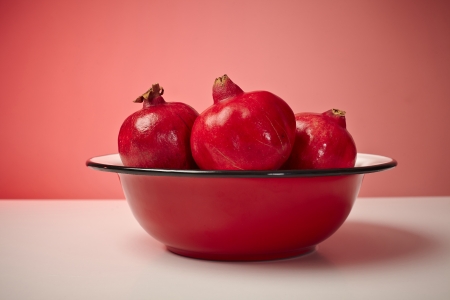 Red pomegranate fruit in a plate on table.の写真素材
