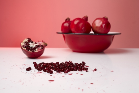 Red pomegranate fruit in a plate on table.の写真素材
