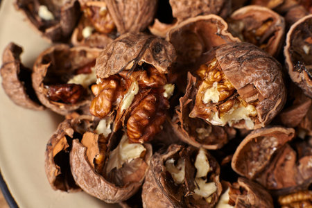 Close up of walnuts cracked open on a wooden table