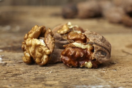 Close up of walnuts cracked open on a wooden tableの写真素材