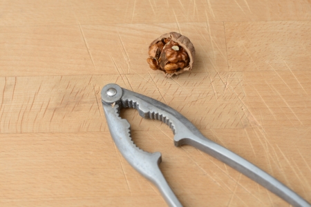 walnuts cracked open with a vintage nut crackerの写真素材