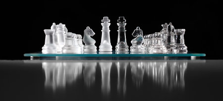glass chess board with chess pieces on.の写真素材