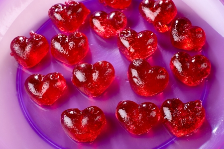 Valentines day, red sweet candies in heart shape, into a purple plateの写真素材