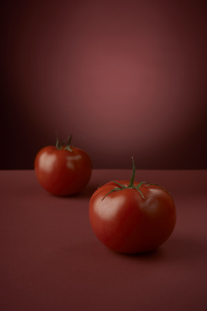 fresh red tomatoes on a red backgroundの写真素材