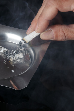 Hand with a cigarette and an ashtray.の写真素材