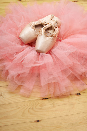 pair of ballet shoes pointes with ribbons on wooden floorの写真素材
