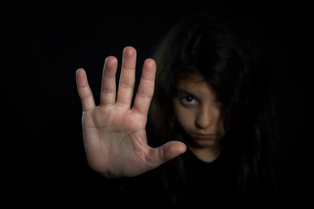 Children violence  Girl with her hand extended signaling to stop の写真素材