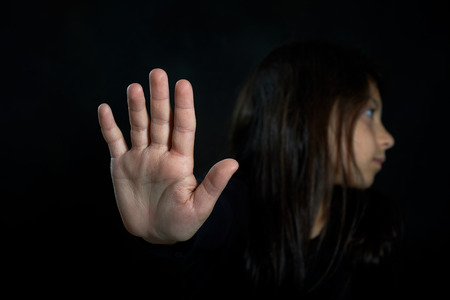Children violence  Girl with her hand extended signaling to stop の写真素材