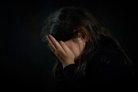 Portrait of a crying girl  She is covering her face の写真素材
