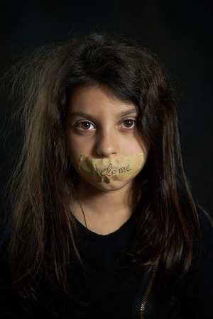 Help me  Disheveled girl with taped mouth の写真素材