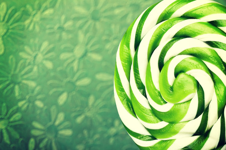 green and white large spiral lollipop on stickの写真素材
