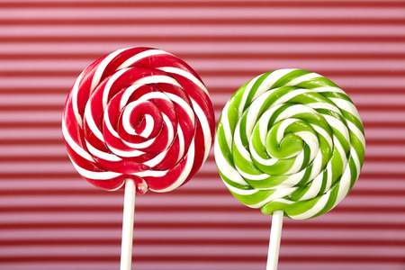 green red and white large spiral lollipop on stickの写真素材