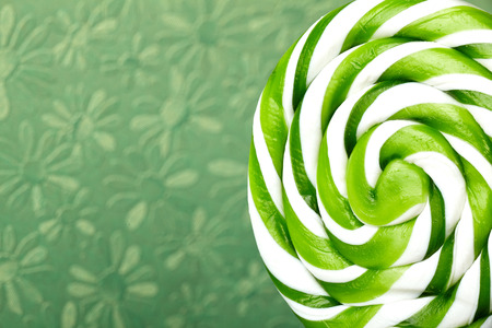 green and white large spiral lollipop on stickの写真素材