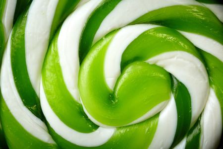 green and white large spiral lollipop on stickの写真素材