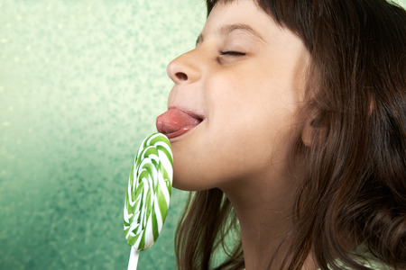 girl enjoy licking a large spiral lollipop.の写真素材