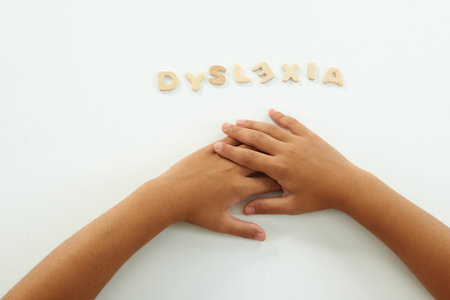 hands of a girl form the word dyslexia with wooden lettersの写真素材