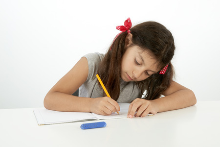 education and school concept. Little girl writing with pencilの写真素材
