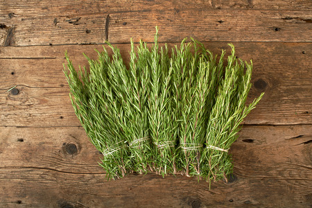 bunch of fresh rosemary on a wooden benchの写真素材