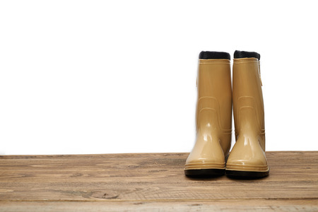 Plastic waterproof boots on a wooden tableの写真素材